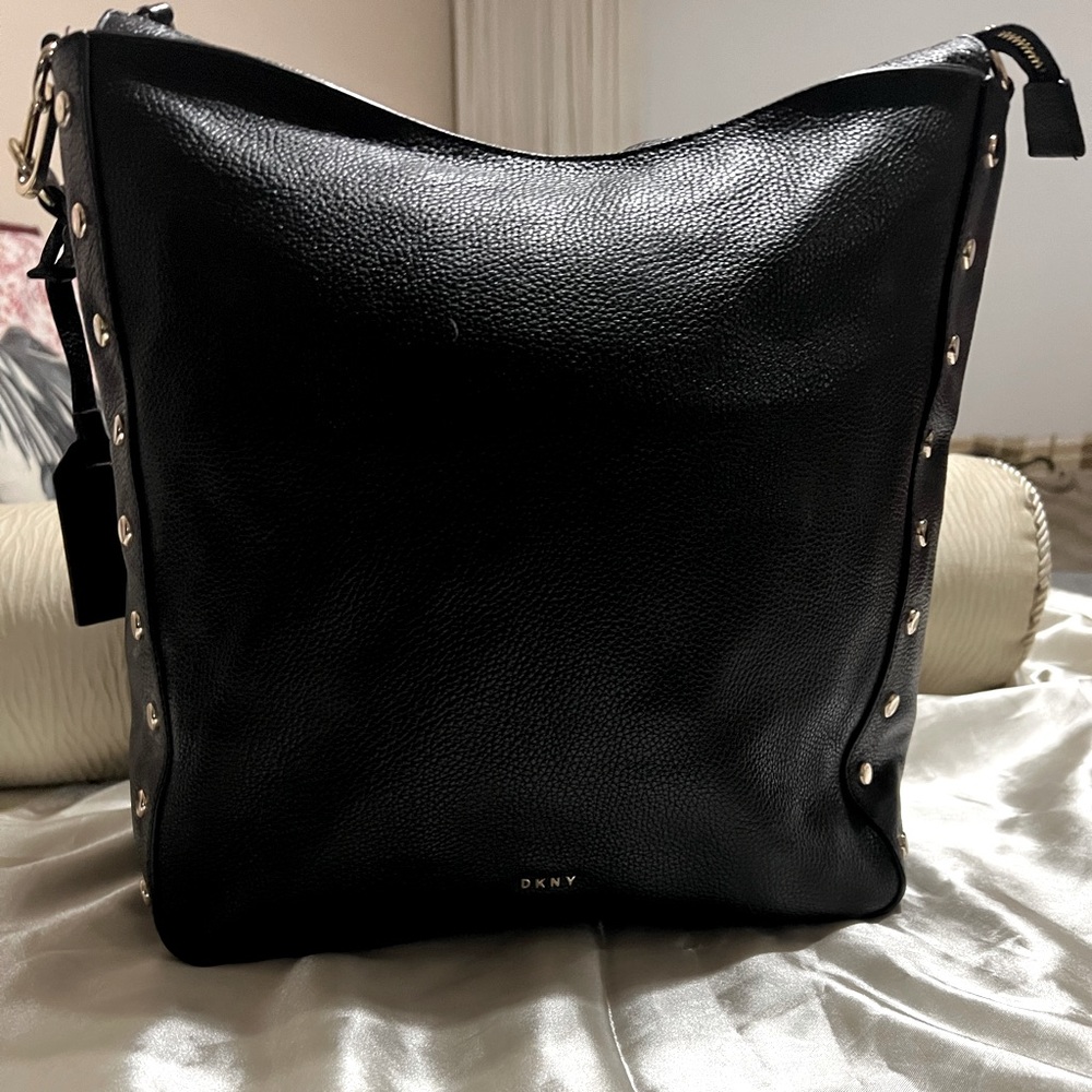 Authentic DKNY leather handbag. Gold grommet accents. Chic bag !